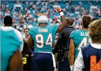  ?? ALLEN EYESTONE / THE PALM BEACH POST ?? Dolphins defensive end Robert Quinn raises his fist Thursday during the playing of the national anthem at a preseason game against the Tampa Bay Buccaneers in Miami. Quinn says he’s preaching “freedom and unity.”