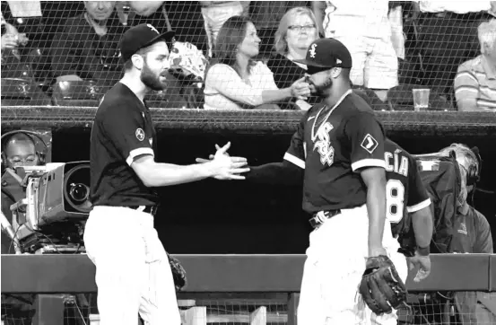  ?? CHARLES REX ARBOGAST/AP ?? Lucas Giolito (left) greets Eloy Jimenez outside the Sox’ dugout after Jimenez emerged unhurt after catching a fly ball at the wall in the third inning Tuesday.