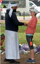  ??  ?? 1 A Muslim man is greeted by a local woman across the road from Al Noor Mosque in Christchur­ch on Tuesday