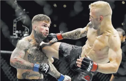  ?? Chris Carlson The Associated Press ?? T.J. Dillashaw follows a punch with a knee to the head of Cody Garbrandt in the first round of their UFC 227 bantamweig­ht title rematch Saturday at Staples Center in Los Angeles. Dillashaw retained the belt by knockout.