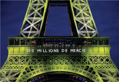  ??  ?? Giochi di luce La scritta «trecento milioni di grazie» apparsa ieri sera sulla Tour Eiffel illuminata a festa