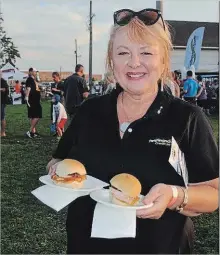  ?? BRANDY FORD SPECIAL TO THE WELLAND TRIBUNE ?? Jodi Vizza, Pen Financial’s brand director, works her way through the five choices of sliders at the second annual Sliderfest in Fonthill Saturday.