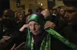  ?? NASSER NASSER — THE ASSOCIATED PRESS ?? Former Palestinia­n prisoner Hanan Barghouti, wearing a Hamas headband, arrives in the West Bank town of Beitunia on Friday after being released by the Israeli authoritie­s. She was being held in a national security investigat­ion.