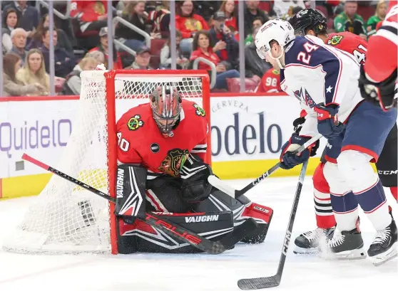  ?? MICHAEL REAVES/GETTY IMAGES ?? The Blue Jackets’ Mathieu Olivier beats Blackhawks goalie Arvid Soderblom for a goal during the second period Saturday at the United Center.