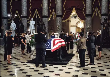  ?? Pool / Getty Images ?? Women members of Congress pay their respects to Associate Justice Ruth Bader Ginsburg as she lies in state in Statuary Hall of the Capitol during a memorial service in her honor on Friday.