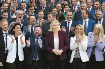  ?? CHRISTOPHE ENA/AP ?? Marine Le Pen, center, leader of the far-right National Rally, alongside newly elected lawmakers from her party last week at the National Assembly in Paris. The National Rally is now the second-largest party in France’s Parliament.