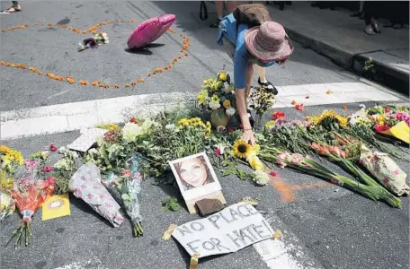  ?? Chip Somodevill­a Getty Images ?? FLOWERS surround a photograph of Heather Heyer in Charlottes­ville, Va. She died in a car attack during a white nationalis­t march.