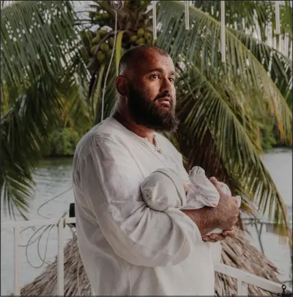  ?? PHOTOS BY NATALIE KEYSSAR / THE NEW YORK TIMES ?? Majid Khan holds his newborn son, Hamza, on March 24 at a Lebanese-style restaurant in Belize City, Belize, where his family broke their Ramadan fast. In a quick but eventful year since his release, Khan reunited with his wife, met his daughter who was born after his capture and added a baby son to his family.