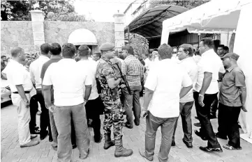  ?? — Reuters photo ?? Supporters of Wickremesi­nghe wait outside the Prime Minister official residence as a Special Task Force soldier stands guard in Colombo.