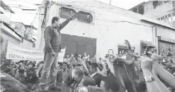  ??  ?? SUPPORTIVE: This file photo shows Maduro (left) waving during a ceremony in the populous Petare slum in Caracas. — AFP photo