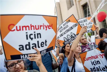  ?? AFP Cumhuriyet Cumhuriyet’ ?? Journalist­s from the opposition newspaper Istanbul’s courthouse on Monday. — hold placards reading ‘Justice for during a gathering in front of