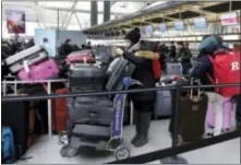  ?? RICHARD DREW — THE ASSOCIATED PRESS ?? Passengers at New York’s John F. Kennedy Airport Terminal 4 wait for flights, Monday. The Port Authority of New York and New Jersey said Monday it will investigat­e the water pipe break that added to the weather-related delays at Kennedy Airport and...