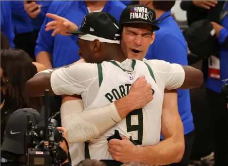  ?? Kevin C. Cox/Getty Images ?? Milwaukee’s Brook Lopez embraces Bobby Portis after the Bucks advanced to their first NBA Finals since 1974.