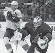  ?? KARL B DEBLAKER AP ?? Carolina goaltender Curtis McElhinney blocks a shot as Jonathan Huberdeau waits for the rebound Friday.