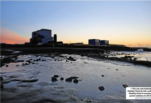  ?? Matt Cardy/Getty Images ?? The sun sets behind Hinkley Point B, left, and Hinkley Point A nuclear power stations in 2013