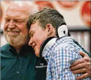  ?? JONATHAN QUILTER / COLUMBUS DISPATCH ?? Logan gets a hug from his grandpa Rick Cole after the assembly at West Liberty-Salem High School in March.