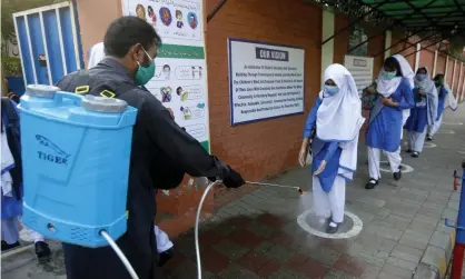  ??  ?? ‘Many poorer countries already face dangerous amounts of indebtedne­ss, with 64 countries currently paying more on debt servicing than on healthcare.’ A student has her shoes disinfecte­d at a school in Lahore, Pakistan. Photograph: KM Chaudary/AP