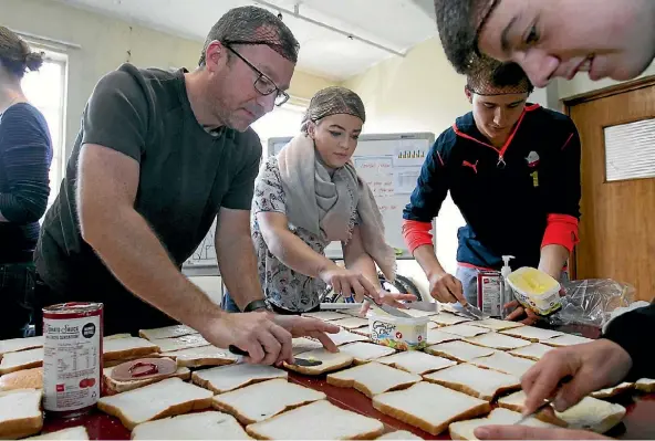  ?? PHOTO: MONIQUE FORD ?? Sandwich making volunteers, from left, Nathan Bentley, Maisy Bentley, Mason Celliher and Owen Parker-Price get into their work creating 1200 lunches at Ole Football Academy on Sunday.