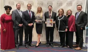  ??  ?? Scott Street, second from left, and Alex Bennett, third, accept the award for Category IV Business of the Year on March 3 at the DoubleTree Hotel in Little Rock.