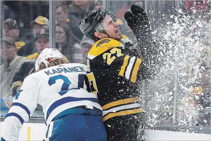  ?? WINSLOW TOWNSON THE ASSOCIATED PRESS ?? Toronto’s Kasperi Kapanen, left, checks Boston’s John Moore into the boards in the Bruins’ 5-1 win over the Maple Leafs on Saturday night.