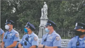  ?? (AP/Matt Slocum) ?? Philadelph­ia police officers gather near the statue of Christophe­r Columbus at Marconi Plaza. Demonstrat­ors in other cities have toppled Columbus statues.