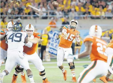  ?? JOE ROBBINS/GETTY IMAGES ?? UM quarterbac­k Brad Kaaya passes in the second quarter of Wednesday’s Russell Athletic Bowl against the West Virginia Mountainee­rs. Kaaya was 24 of 34 for 282 yards and four touchdowns and was named the game’s most valuable player.