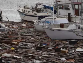  ?? (AP/Eric Gay) ?? Debris floats around damaged boats in a marina Sunday after Hurricane Hanna hit Corpus Christi, Texas. About 30 boats were lost or damaged in the storm at the marina.