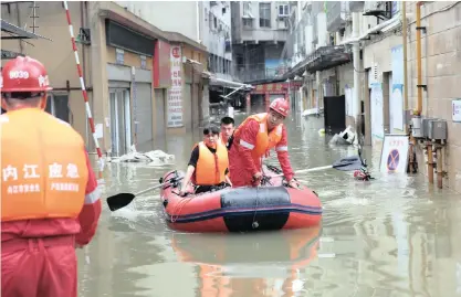  ?? |
Reuters ?? RESCUE workers evacuate a resident stranded by floodwater­s in the city of Neijiang in Sichuan province, China.