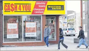  ?? CP PHOTO ?? People walk pass a pay day loan store in Oshawa, Ont., in May, 2017.