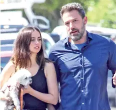  ??  ?? Ben Affleck and Ana de Armas walk with their dog.