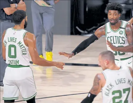  ?? MARK J. TERRILL / AP ?? Boston Celtics' Marcus Smart, top right, talks with teammates Jayson Tatum and Daniel Theis during the first half of Game 6 of the Eastern Conference finals on Sunday night.