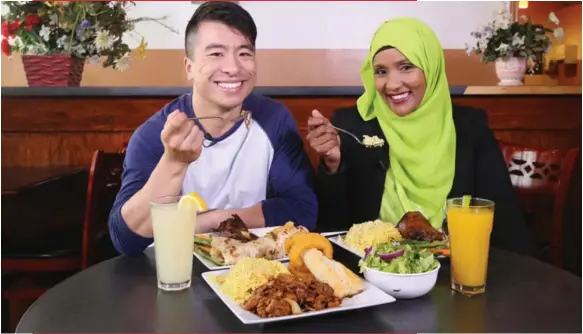  ?? VINCE TALOTTA/TORONTO STAR ?? The Star’s Karon Liu and TV host Hodan Nalayeh check out the menu at Bilal restaurant in Rexdale.