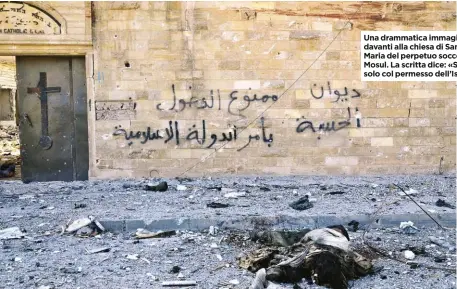  ??  ?? Una drammatica immagine davanti alla chiesa di Santa Maria del perpetuo soccorso, a Mosul. La scritta dice: «Si entra solo col permesso dell’Isis».