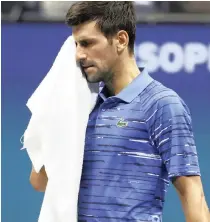  ?? GEOFF BURKE ?? NOVAK Djokovic wipes his face during his match against Stan Wawrinka at the US Open on Sunday. |