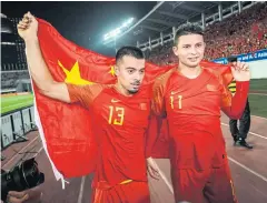  ?? AFP ?? China stars Li Ke, left, and Elkeson celebrate after winning a World Cup qualifier in Guangzhou last year.