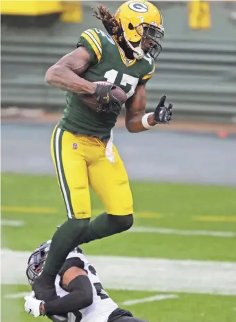  ?? DAN POWERS / USA TODAY ?? Packers wide receiver Davante Adams jumps into the end zone for a touchdown despite the effort of Jaguars cornerback C.J. Henderson.