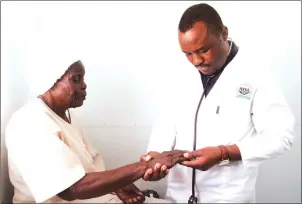  ?? — Picture by Kudakwashe Hunda ?? Dr Humphrey Mapuranga attends to Mrs Maria Chihomo from Kuwadzana 7 during a free medical service to farmers and the disadvanta­ged by NSSA at Boka Tobacco Auction Floors in Harare yesterday.