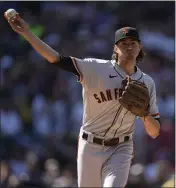  ??  ?? Giants starting pitcher Kevin Gausman turns to make a pick-off throw in the third inning Monday against the Rockies in Denver.