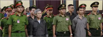  ?? — AFP photo ?? Vinh (second left) and other activists who were charged of subversion, stand trial in Ho Chi Minh city.