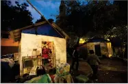  ?? AP PHOTO BY REBECCA BLACKWELL ?? In this March 14, 2018 photo, members of the Marquez family talk outside the temporary shelter where seven children and four adults from the family are living in a park, six months after an earthquake damaged in Mexico City.