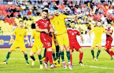  ??  ?? PEREBUTAN bola di udara antara pemain Australia Mathew Leckie (kanan) dan pemain Syria Khaled Al Mbayed.
