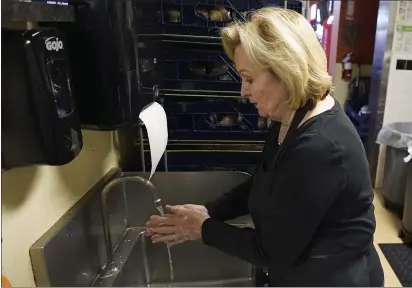  ?? RICH PEDRONCELL­I — THE ASSOCIATED PRESS ?? Brenda Luntey washes her hands while working at the San Francisco Deli in Redding on Dec. 3.