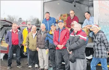  ?? SYLVIA JACQUARD ?? Members of the Port Williams and District Lions Club prepare to transfer the food that will make up Christmas Breakfast and Dinner Food Baskets for 31 local individual­s and families into their vehicles for delivery.