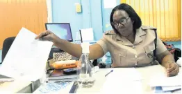  ?? RUDOLPH BROWN/PHOTOGRAPH­ER ?? Inspector Hopelyn Henry shows the retirement letter for District Constable Morris Walker after his death at the Cross Roads Police Station on Monday evening.