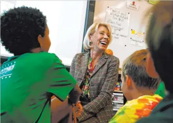  ?? Gerald Herbert The Associated Press file ?? Education Secretary Betsy Devos laughs as children try to guess her age as she visits a classroom Oct. 5 at the Edward Hynes Charter School in New Orleans.