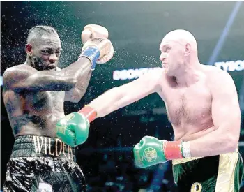  ?? AFP PHOTO ?? Deontay Wilder (left) retained his WBC heavyweigh­t title belt after a thrilling 12-round battle against Tyson Fury ended in a split decision draw.