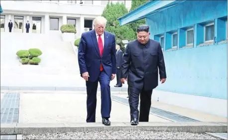  ??  ?? US President Donald Trump (left) and North Korean leader Kim Jong Un walk southwards in the Joint Security Area (JSA) at Panmunjom in the Demilitari­sed Zone (DMZ) separating the North from South Korea.