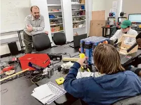  ?? Andy Tsubasa Field/times Union ?? Jacob Bruno, a University at Albany senior, receives instructio­n from engineerin­g professor Jonathan Muckell while working on his team's mail sorting machine motors.