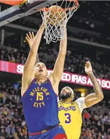  ?? AARON ONTIVEROZ GETTY IMAGES ?? Nuggets center Nikola Jokic, who had 34 points, 21 rebounds and 14 assists, goes up for a dunk in front of Lakers center Anthony Davis, who had 40 points and 10 rebounds, during the second quarter in Game 1 of Western Conference finals at Ball Arena in Denver on Tuesday.