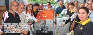  ??  ?? Rogayah ( second right, front row) commission­s the composting machine at the central market. Jong is at second left while Wong is at third right (front row).